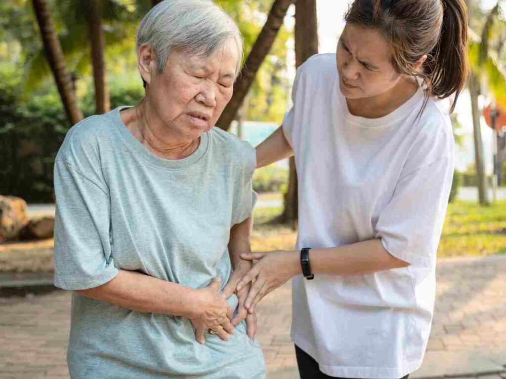 woman helping her mother with side pain.