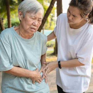 woman helping her mother with side pain.