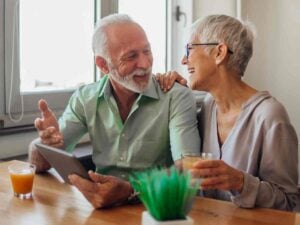 man and woman sitting at table, laughing with each other.