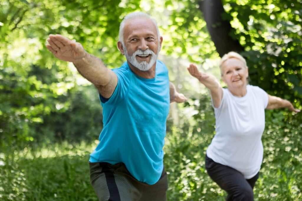 man and woman with arms spread in the outdoors.