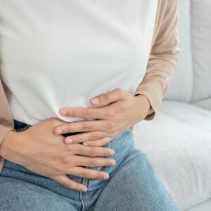 woman holding stomach.