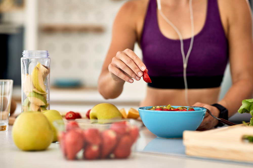 woman eating fruit from a bowl.