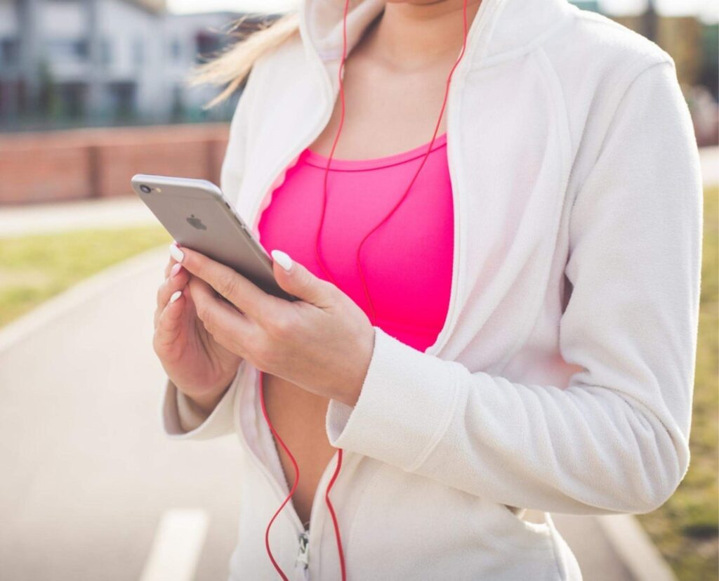 woman holding phone, exercising.