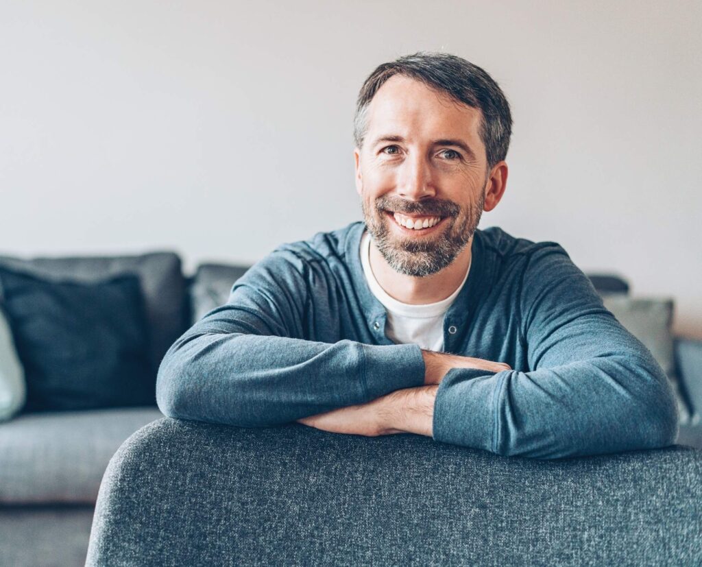 man sitting smiling at camera.
