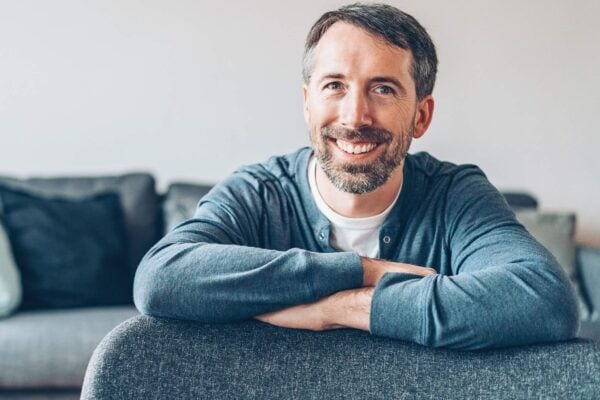 man sitting smiling at camera.