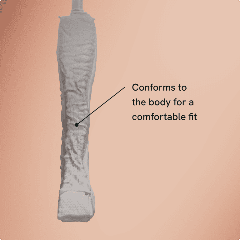 A white sanitary product with a textured surface is shown on a peach gradient background. A label points to the product, stating, Conforms to the body for a comfortable fit. Featured Partner: Aeroflow Urology.