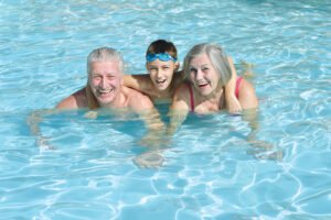 family swimming in pool.
