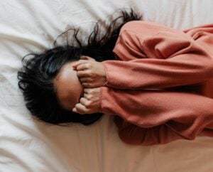 woman holding hands over her eyes.