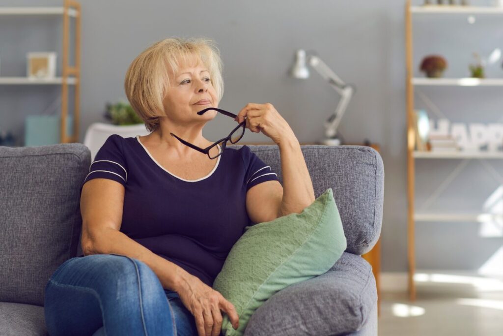 woman sitting on couch holding glasses.
