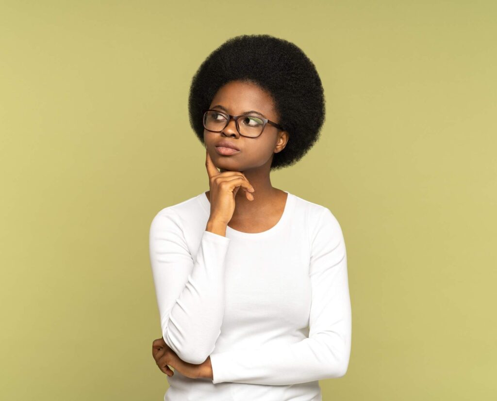 woman wondering about something with finger on chin.