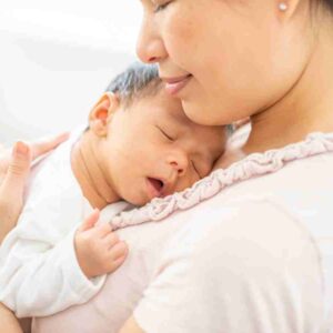 woman with baby on chest.