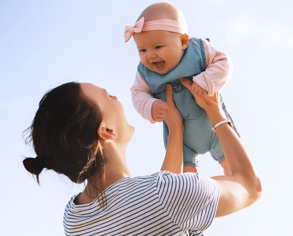woman holding baby in air.