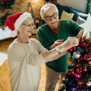 Happy mature couple preparing for Christmas and decorating the t