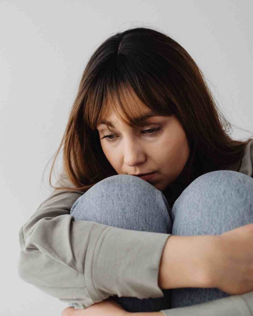 depressed woman hugging knees